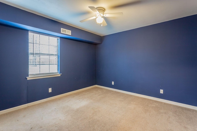 unfurnished room featuring light carpet, a ceiling fan, visible vents, and baseboards