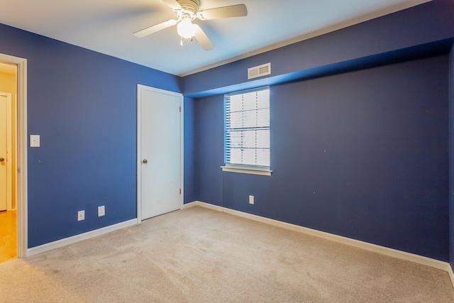 unfurnished room with baseboards, visible vents, a ceiling fan, and light colored carpet