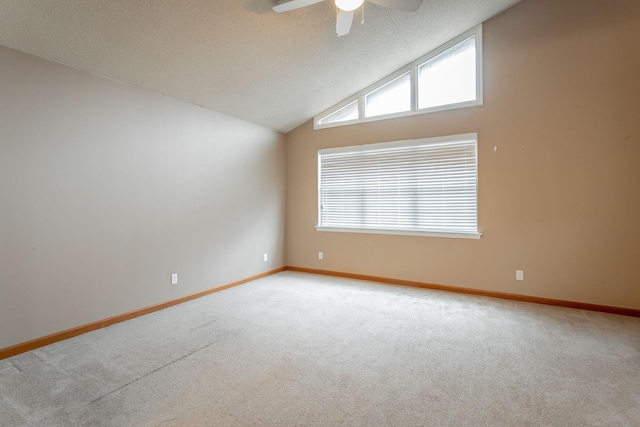 carpeted empty room featuring lofted ceiling, ceiling fan, a textured ceiling, and baseboards