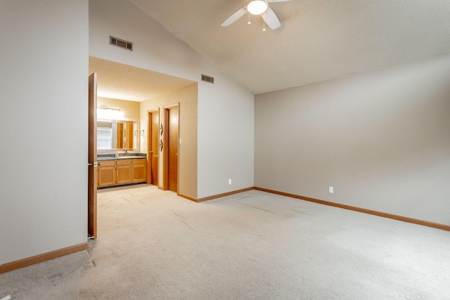 empty room with baseboards, visible vents, ceiling fan, and light colored carpet