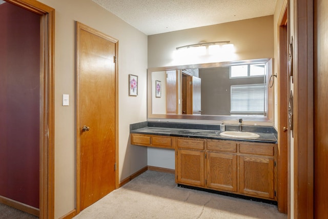 bathroom with baseboards, a textured ceiling, and vanity