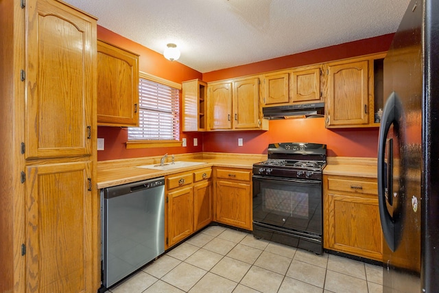 kitchen with brown cabinetry, under cabinet range hood, light countertops, black appliances, and a sink