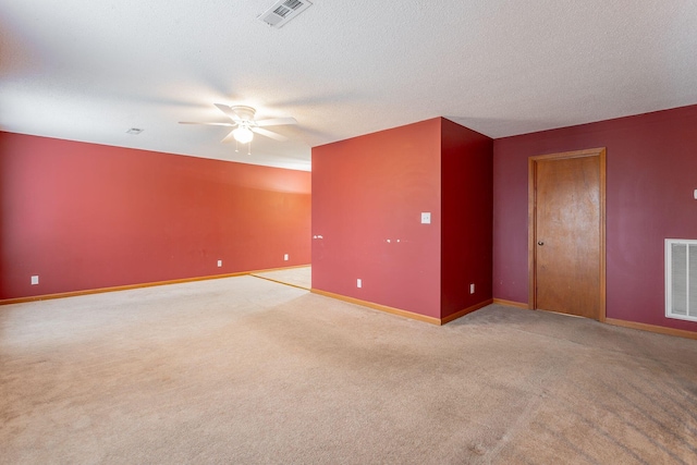 unfurnished room with baseboards, visible vents, a textured ceiling, and light colored carpet