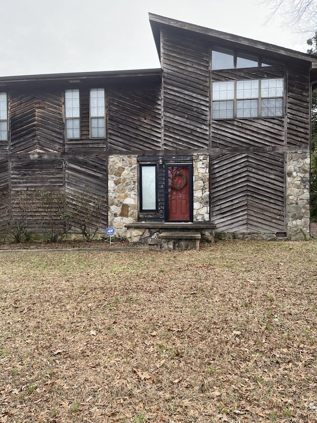 view of front of house with entry steps and a front lawn