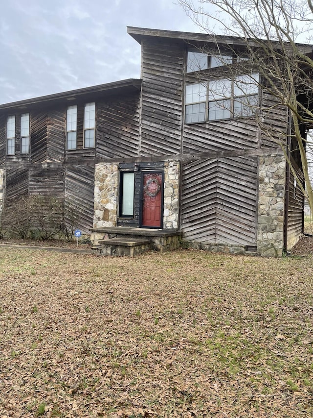 rear view of house featuring a lawn