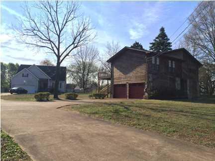 view of property exterior featuring a garage, driveway, and a yard