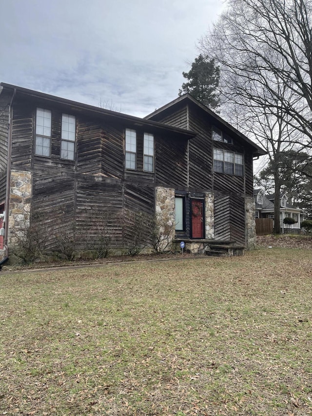 view of front of property featuring stone siding and a front yard