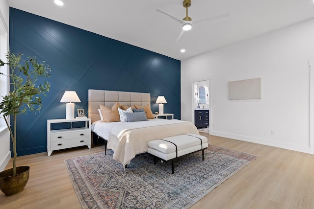 bedroom with ceiling fan, ensuite bath, and light hardwood / wood-style flooring