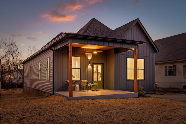 back house at dusk featuring a patio area