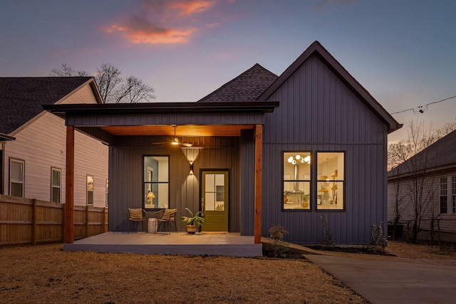 back house at dusk featuring a patio area