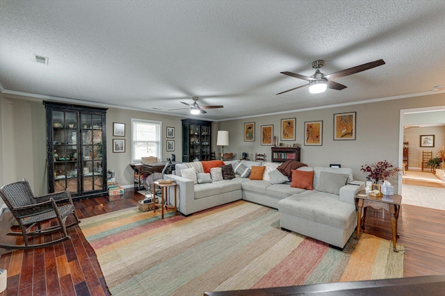 living room with hardwood / wood-style flooring, crown molding, and a textured ceiling