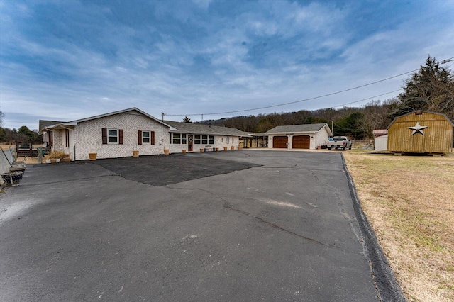 view of front of property featuring a garage, a shed, and a front yard