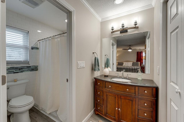 bathroom featuring ornamental molding, vanity, ceiling fan, toilet, and a textured ceiling