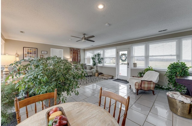 tiled dining area featuring a textured ceiling and a healthy amount of sunlight