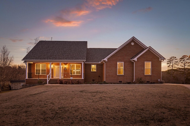 ranch-style home with a yard and covered porch