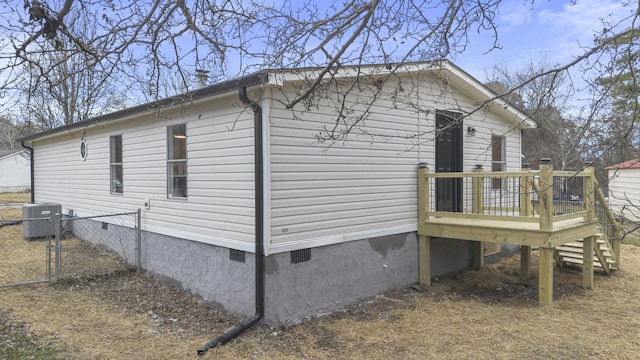 view of side of property with cooling unit and a wooden deck