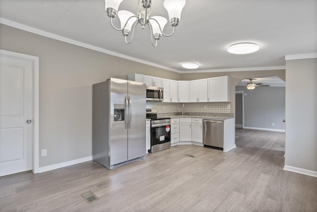 kitchen with crown molding, stainless steel appliances, decorative backsplash, white cabinets, and decorative light fixtures