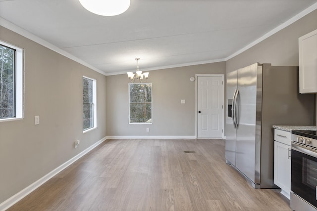 unfurnished dining area featuring ornamental molding, an inviting chandelier, and light hardwood / wood-style floors