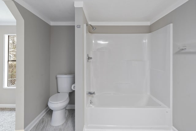 bathroom with shower / tub combination, ornamental molding, and toilet