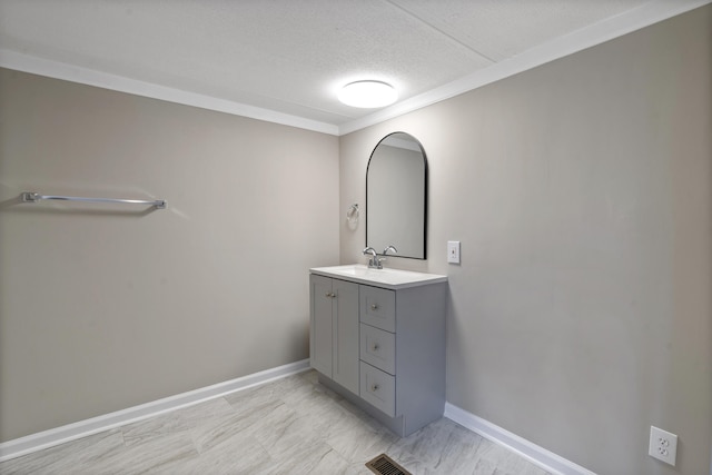 bathroom featuring ornamental molding, vanity, and a textured ceiling