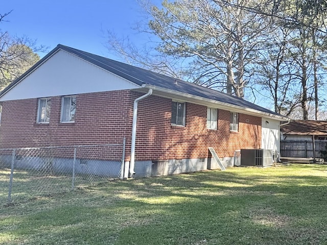 view of side of property featuring central AC unit and a lawn