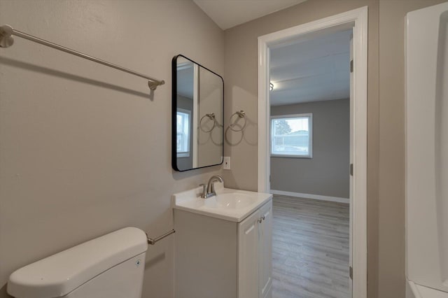 bathroom with hardwood / wood-style flooring, vanity, and toilet