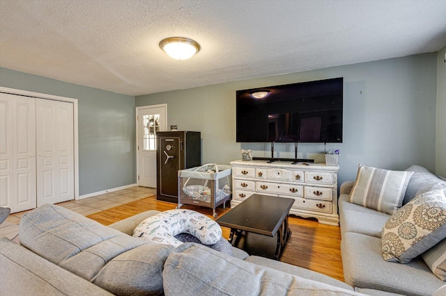 living room with a textured ceiling and light wood-type flooring