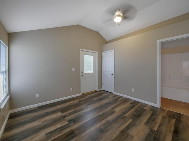 spare room with vaulted ceiling, dark wood-type flooring, and ceiling fan