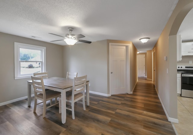 dining area featuring ceiling fan, wood-type flooring, and a textured ceiling