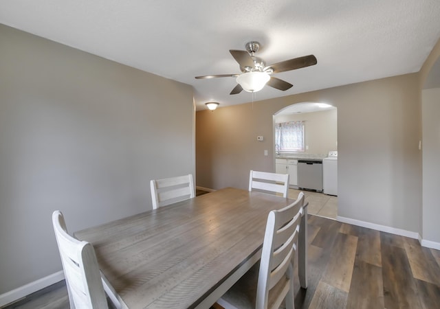 dining room with dark hardwood / wood-style flooring, washer / dryer, and ceiling fan