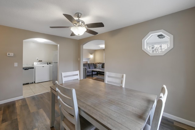 dining space with ceiling fan, washing machine and clothes dryer, and wood-type flooring