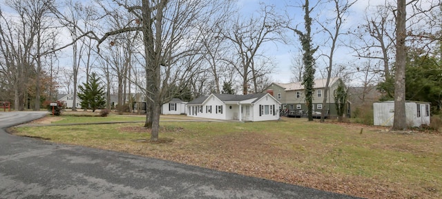 view of front of home with a storage shed and a front yard