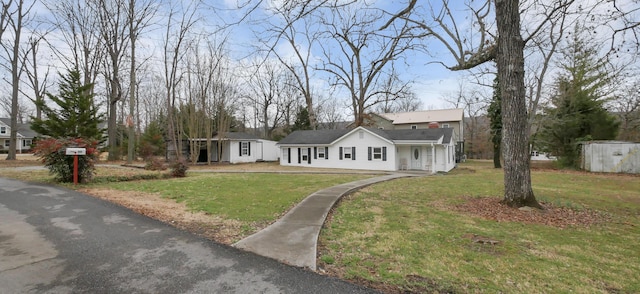 single story home with a front lawn and a shed