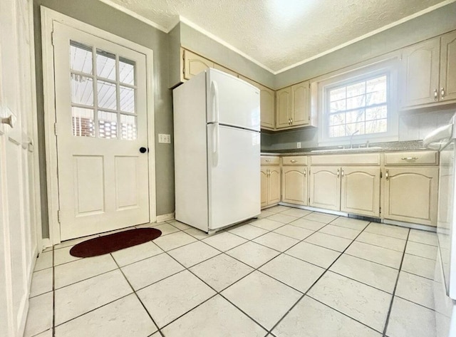 kitchen featuring sink, light tile patterned flooring, a textured ceiling, and white fridge