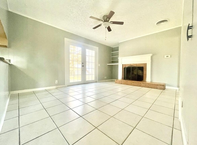 unfurnished living room featuring light tile patterned floors, built in shelves, french doors, and a textured ceiling