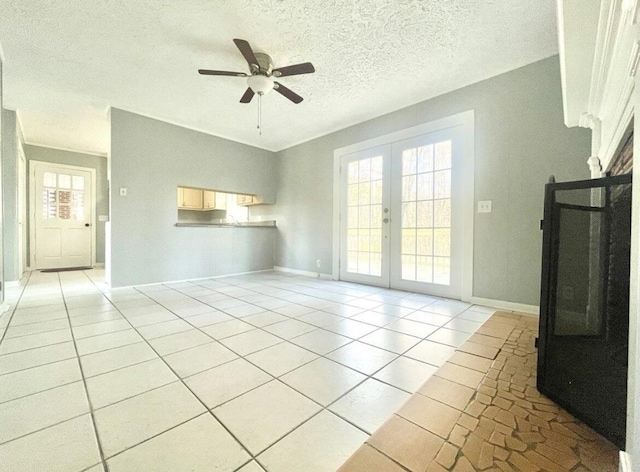 unfurnished living room with light tile patterned flooring, ceiling fan, a textured ceiling, and french doors