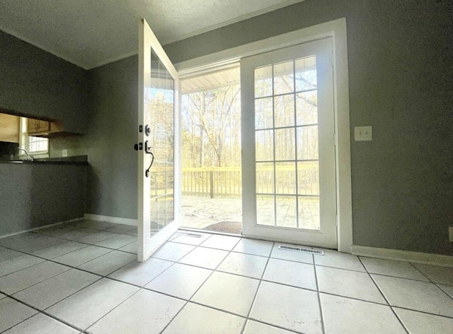 doorway with light tile patterned floors and plenty of natural light