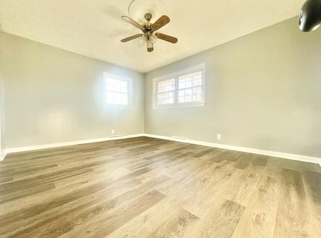 spare room with a textured ceiling, wood-type flooring, and ceiling fan