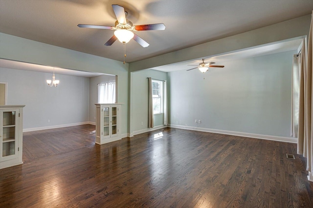 spare room featuring dark hardwood / wood-style flooring and ceiling fan with notable chandelier