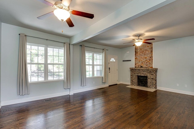 unfurnished living room with a brick fireplace, dark hardwood / wood-style floors, and ceiling fan