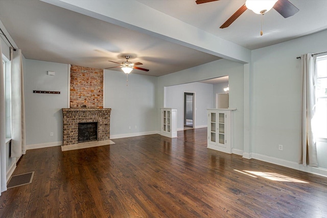 unfurnished living room featuring ceiling fan, dark wood-type flooring, and a fireplace