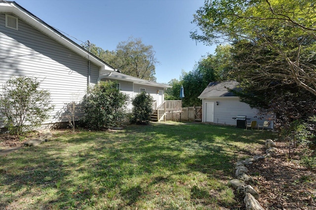 view of yard with a wooden deck and an outbuilding