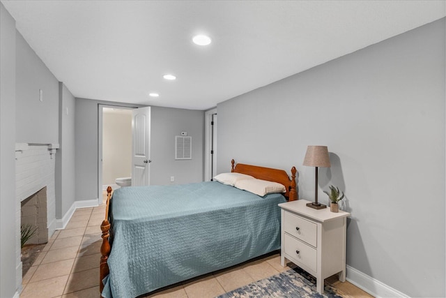 bedroom featuring a brick fireplace and light tile patterned floors