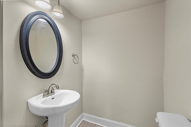 bathroom with tile patterned flooring, sink, and toilet