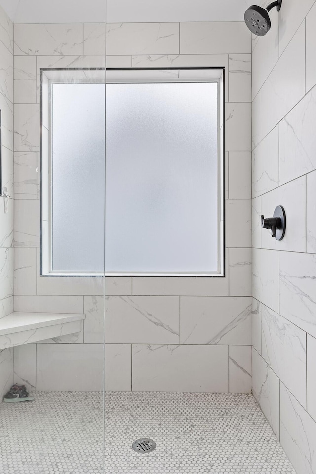 bathroom featuring tiled shower and a wealth of natural light