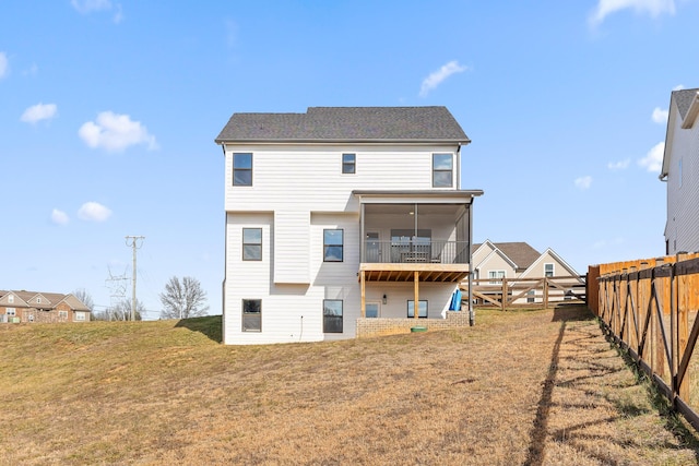 rear view of property featuring a sunroom and a yard