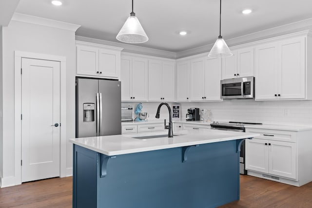 kitchen with appliances with stainless steel finishes, decorative light fixtures, sink, and white cabinets