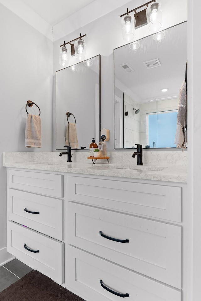 bathroom with vanity and tiled shower