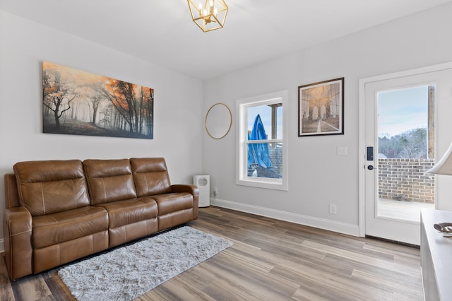 living room with a notable chandelier and light hardwood / wood-style floors