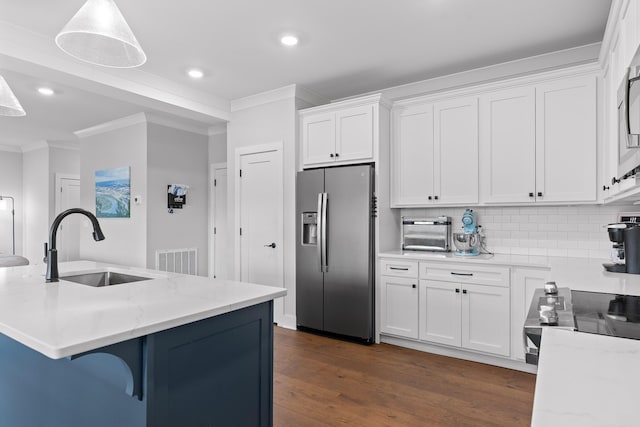 kitchen featuring appliances with stainless steel finishes, decorative light fixtures, white cabinetry, sink, and crown molding